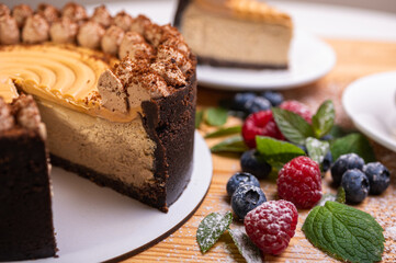 close-up of cheesecake with cream filling, decorated with fresh berries, blueberries and raspberries, festive New Year's cake, Christmas	
