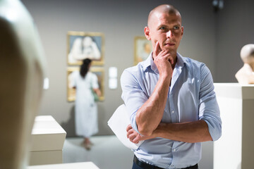 Middle aged man observing exhibits in museum