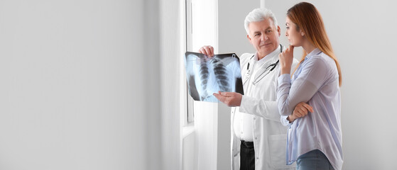 Senior doctor with x-ray image of lungs and female patient in clinic. Banner for design - obrazy, fototapety, plakaty