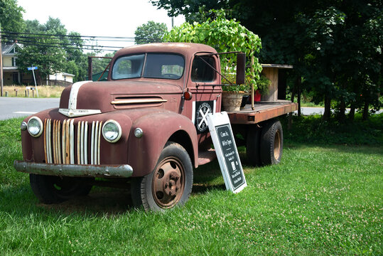 vintage 50's Ford pickup truck is parked on the lawn advertising a local store.