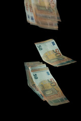 Stroboscopic photo of falling euro banknotes on dark background