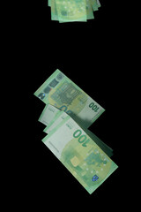 Stroboscopic photo of falling euro banknotes on dark background