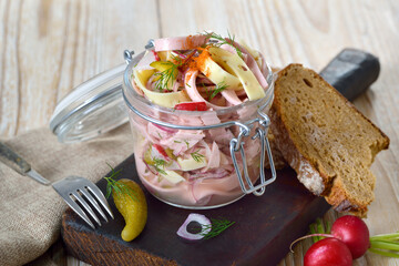 Deftiger Schweizer Wurstsalat mit Käsestreifen und Essiggurken im Glas, dazu rustikales Bauernbrot...