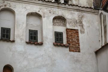 Fototapeta na wymiar Old tiny wooden windows in an old building facade in Riga