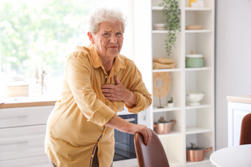 Senior woman having heart attack in kitchen