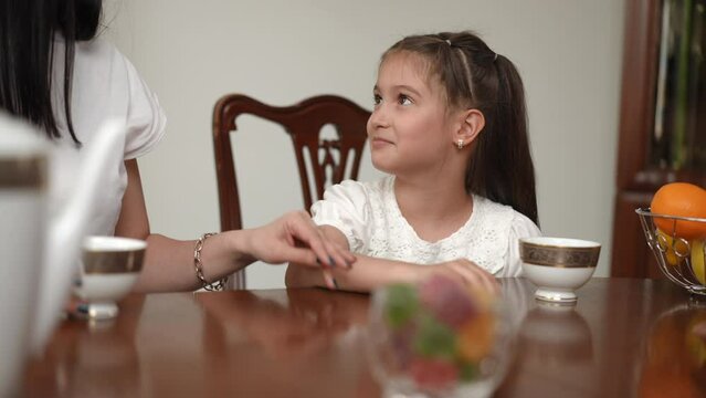 Tea drinking in a modern house. Mom does not want her daughter to become accustomed to sugar-containing foods