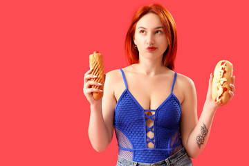 Thoughtful young woman with different hot dogs on red background