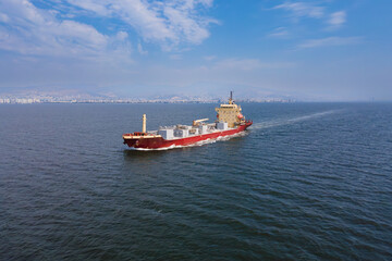 Cement bulk carrier vessel full loaded cruising at sea. Aerial shot