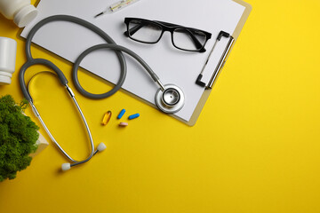 Doctor's desk top view. Set of different doctor accessories on a colored background. Pills,...