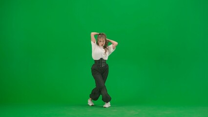 In the frame on a green background, chromakey. A young, slender, beautiful girl is dancing. She demonstrates various dance moves in the direction of jazz funk. She is rhythmic, plastic. General plan