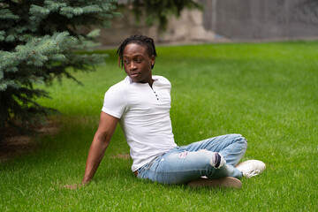 Fototapeta premium having a rest and chill n the park, young person sitting on the grass