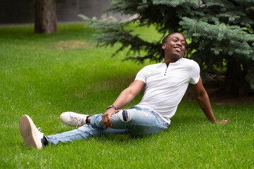 Fototapeta premium having a rest and chill n the park, young person sitting on the grass