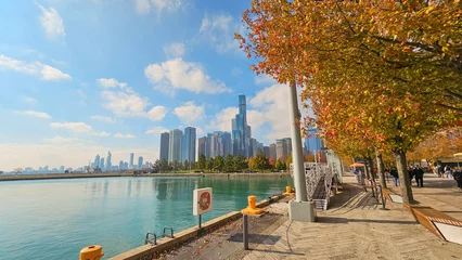 Foto auf Leinwand A beautiful autumn landscape on the banks of Lake Michigan at Navy Pier, autumn trees, people walking, skyscrapers, hotels and office buildings in the city skyline in Chicago Illinois USA © Marcus Jones