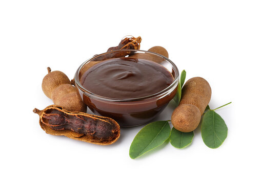 Bowl with tasty tamarind jam and fruits on white background