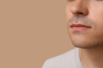 Fototapeta premium Ill young man on brown background, closeup