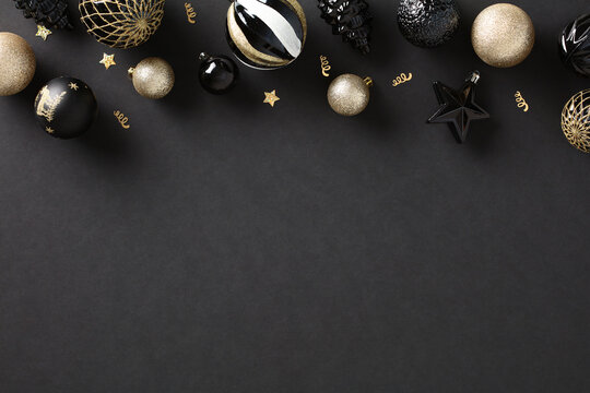 Christmas dark background with luxury golden ball decorations, top view. Xmas greeting card template, Happy New Year banner design.