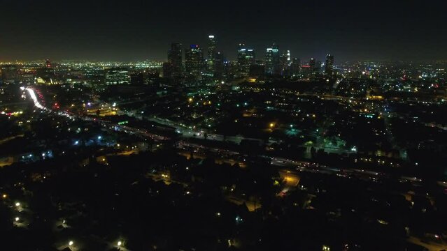 Aerial Lockdown Shot Of Illuminated Skyscrapers Amidst Buildings In City Against Clear Sky At Night - Los Angeles, California
