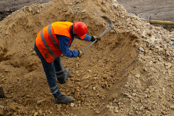 a worker digging with a pick