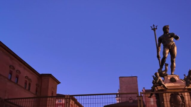 Neptune statue in Bologna majestically juxtaposes historic Accursio Palace in Italy. A touch of vibrancy is brought by a rainbow peace flag as a beacon of unity and harmony amidst ongoing wars of 2023