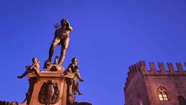 Under the night sky, the Neptune statue in Bologna stands as a majestic beacon, its intricate details highlighted by the soft glow of surrounding lights.