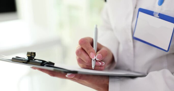 Closeup Of Doctor Hands Filling Out Written Medical Documents Standing In Office