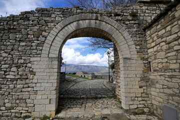 Stone round arch framing the old garrison building and Shpirag Mal-Mount as seen from Kalaja e Beratit-The Castle. Berat-Albania-091