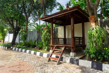 Bali traditional wooden gazebo at the tropical garden. Unity with nature concept, tropical view
