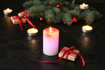 Composition with burning candles, Christmas gifts and fir branches on dark background