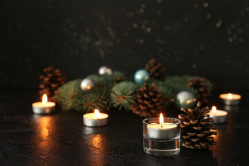 Burning candles, cones and Christmas decorations on dark background