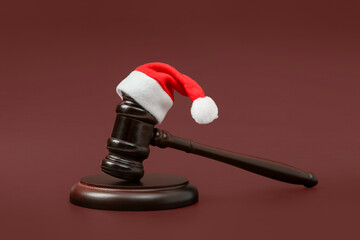 Judge's gavel with Santa hat on color background