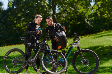 Fototapeta premium A sweet couple, equipped with bicycles and engrossed in coordinating their journey, checks their GPS mobile and watches while planning scenic routes in the park, seamlessly blending technology and