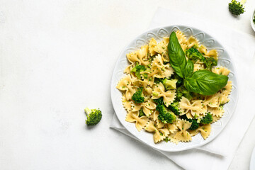 Plate of tasty pasta with broccoli on white background