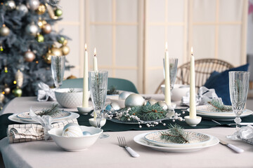 Beautiful table setting with burning candles and Christmas decorations in dining room, closeup