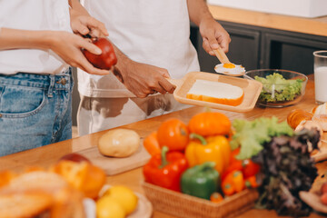 Handsome man sitting near his wife at kitchen. Family couple see social media, surf the web while sitting at kitchen table with generic laptop. Couple working with laptop at home