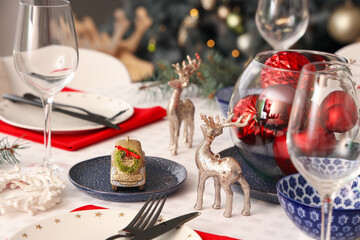 Festive table setting with wine glasses and Christmas decorations, closeup