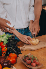 Handsome man sitting near his wife at kitchen. Family couple see social media, surf the web while sitting at kitchen table with generic laptop. Couple working with laptop at home