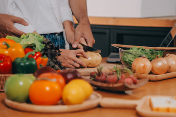 Handsome man sitting near his wife at kitchen. Family couple see social media, surf the web while sitting at kitchen table with generic laptop. Couple working with laptop at home