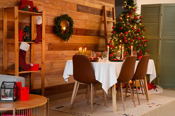Interior of cozy room with Christmas tree, decorations and served dining table