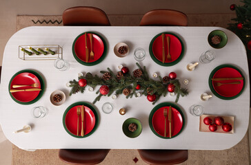 Festive table setting with Christmas decorations and burning candles, top view