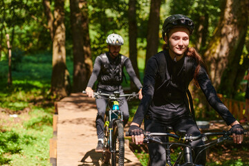 A blissful couple, adorned in professional cycling gear, enjoys a romantic bicycle ride through a park, surrounded by modern natural attractions, radiating love and happiness