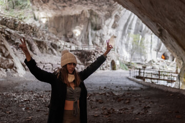 Happy girl explores Zugarramurdi cave, enjoying myths.