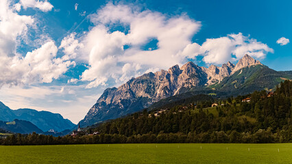 High resolution stitched alpine summer panorama with a church and the Tennengebirge mountains near...