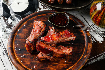 Barbecue pork spare ribs with hot honey chilli marinade on wooden cutting board with sauce on...