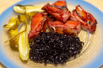 Traditional rustic Brazilian food, black rice, smoked pork ribs and pickles