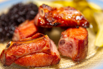 Traditional rustic Brazilian food, black rice, smoked pork ribs and pickles