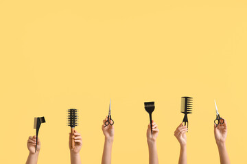 Female hands with different hairdresser's accessories on color background