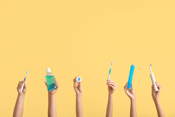 Female hands with oral hygiene supplies on color background