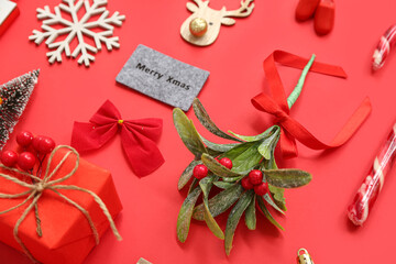 Mistletoe branch with Christmas decorations on red background