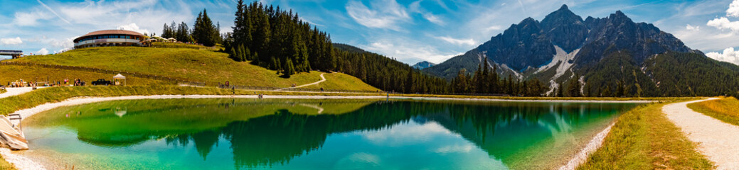 High resolution stitched alpine summer panorama with reflections in a lake at Serles cable car...