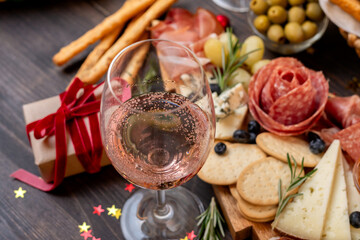 festive aperitif or party two glasses of champagne, Prosecco or rosé wine with cold meat appetizers cheeses and olives